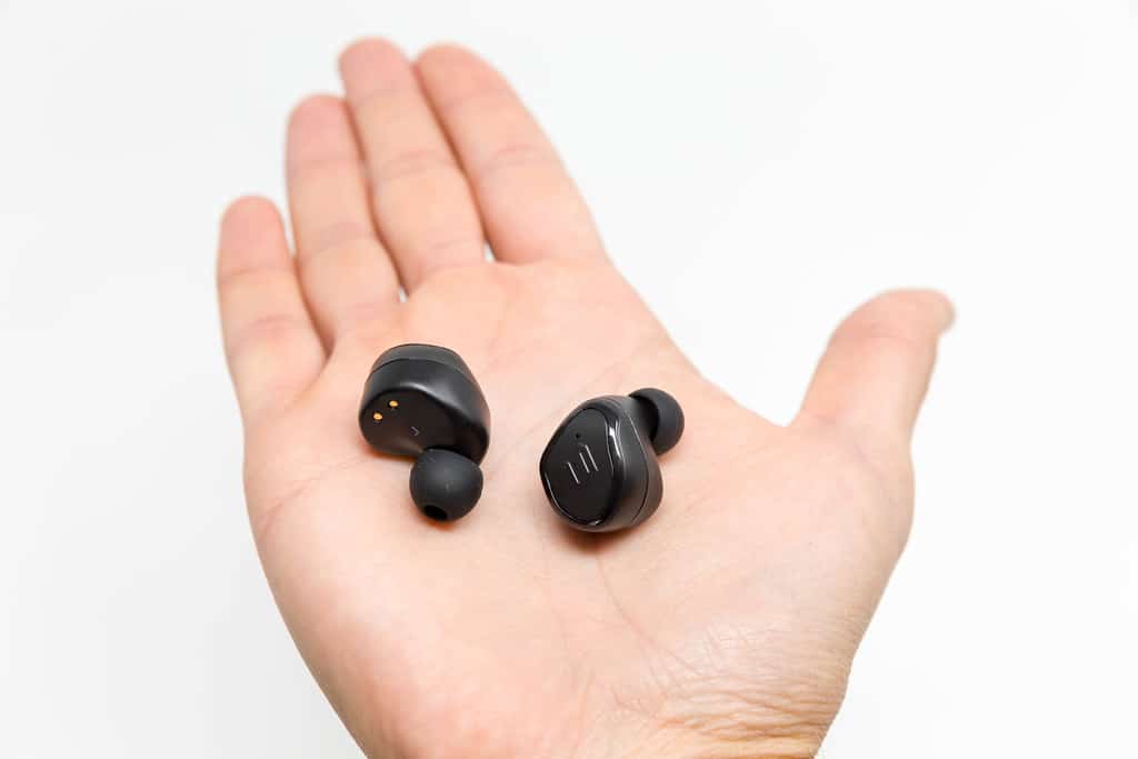 a hand holding wireless earphones : Earphones For Running That Don’t Fall Out