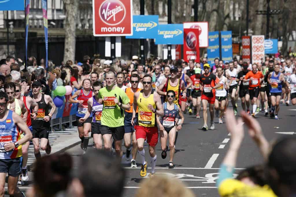 Runners in marathon with people cheering from each side : Funny Marathon Signs