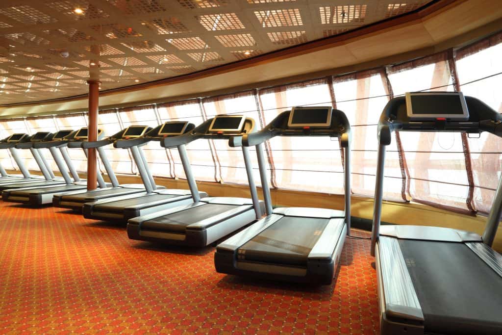 large gym hall with treadmills near windows in cruise ship