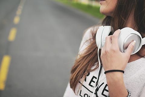 a woman wearing a white headset and looking back at the road 