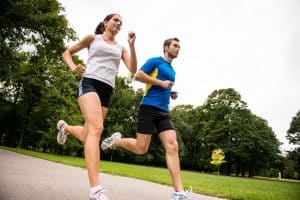 Low angle photo of young couple jogging outdoor in park