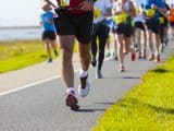 Group of runners compete in the race on coastal road