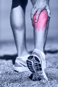 why do my calves hurt when i run: man holding his calf muscle in pain