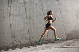 Female sport runner striving into bright future. Fit body requires hard work. Urban sport concept.