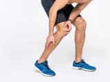 man holding leg in pain