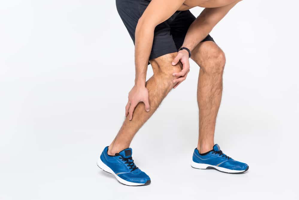 Why Do My Legs Hurt When I Run: man holding leg in pain