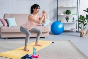 woman squatting on yoga mat