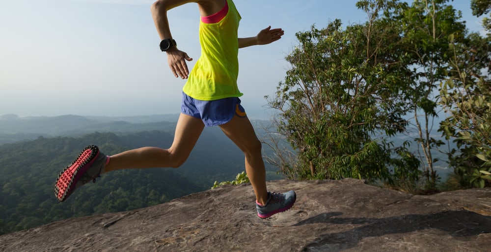Young woman running on mountain peak