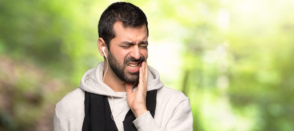 Sport man with toothache in a park