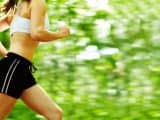young woman runner in a green forest.