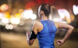 woman running with earphones and arm band