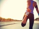 young ftiness woman runner stretching legs before run
