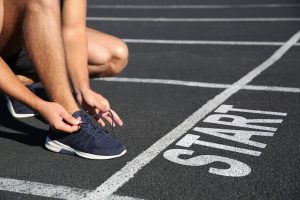 Runner tying shoelaces in front of starting line