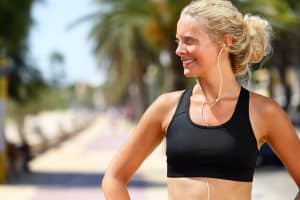 songs about running: Woman runner listening to music in earbuds