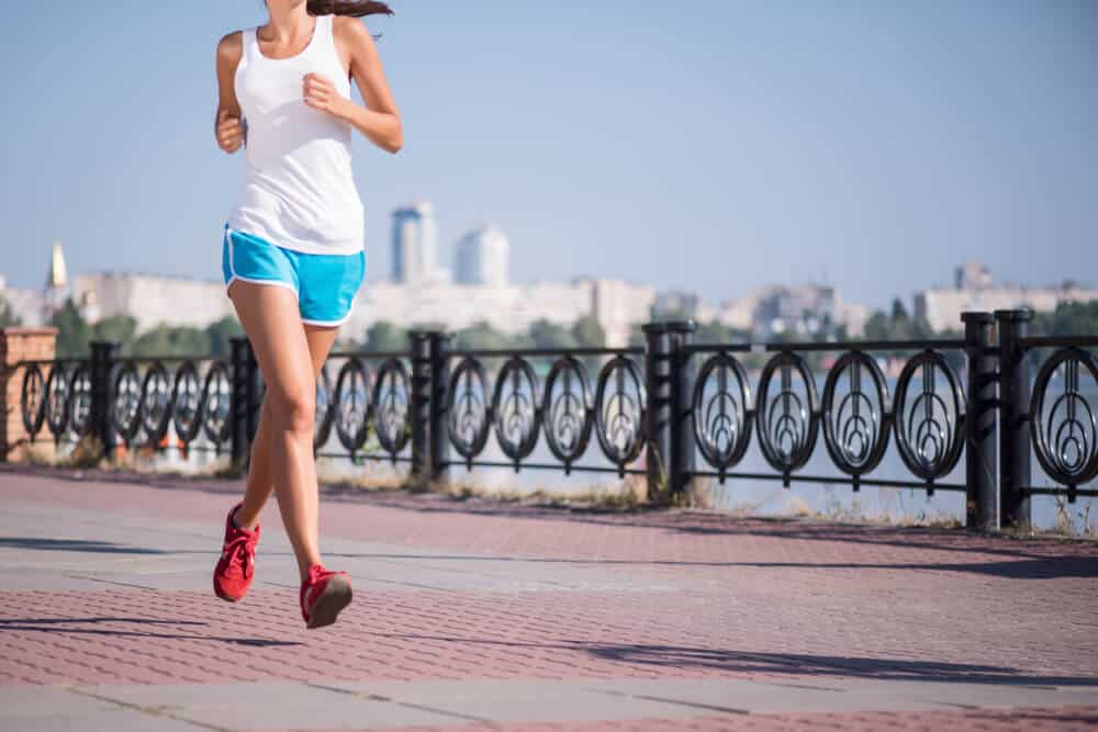 woman running in shorts by the coast