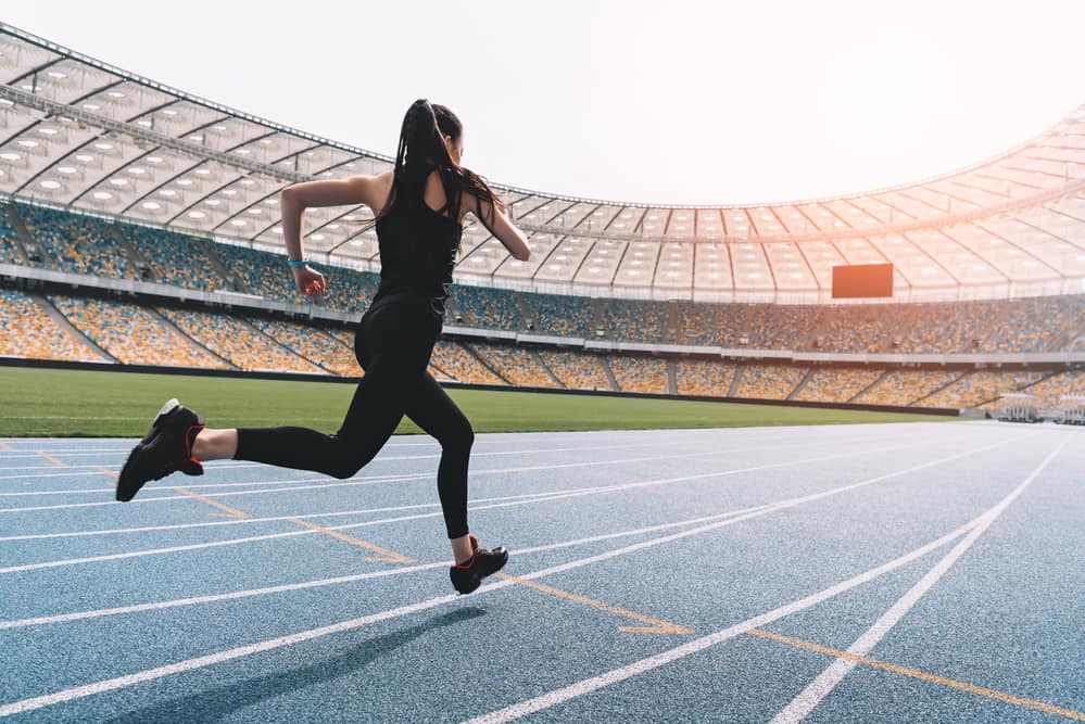 woman running in stadium track