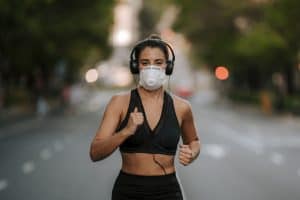 woman running with mask and headphones on