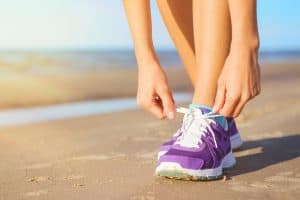 are running shoes supposed to be tight: woman tying running shoes