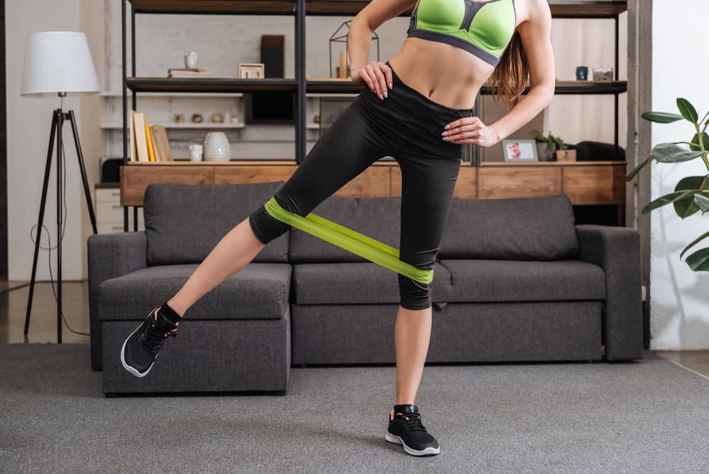 if you’re wondering if you should train with a resistance band for running, here’s what you need to consider:woman exercising with resistance band around her knees