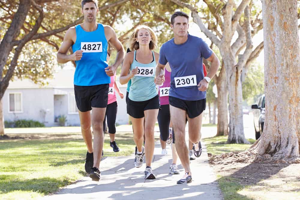 How to Run a 24 Minute 5K: Everything You Need to Know:Group Of Runners On Suburban Street