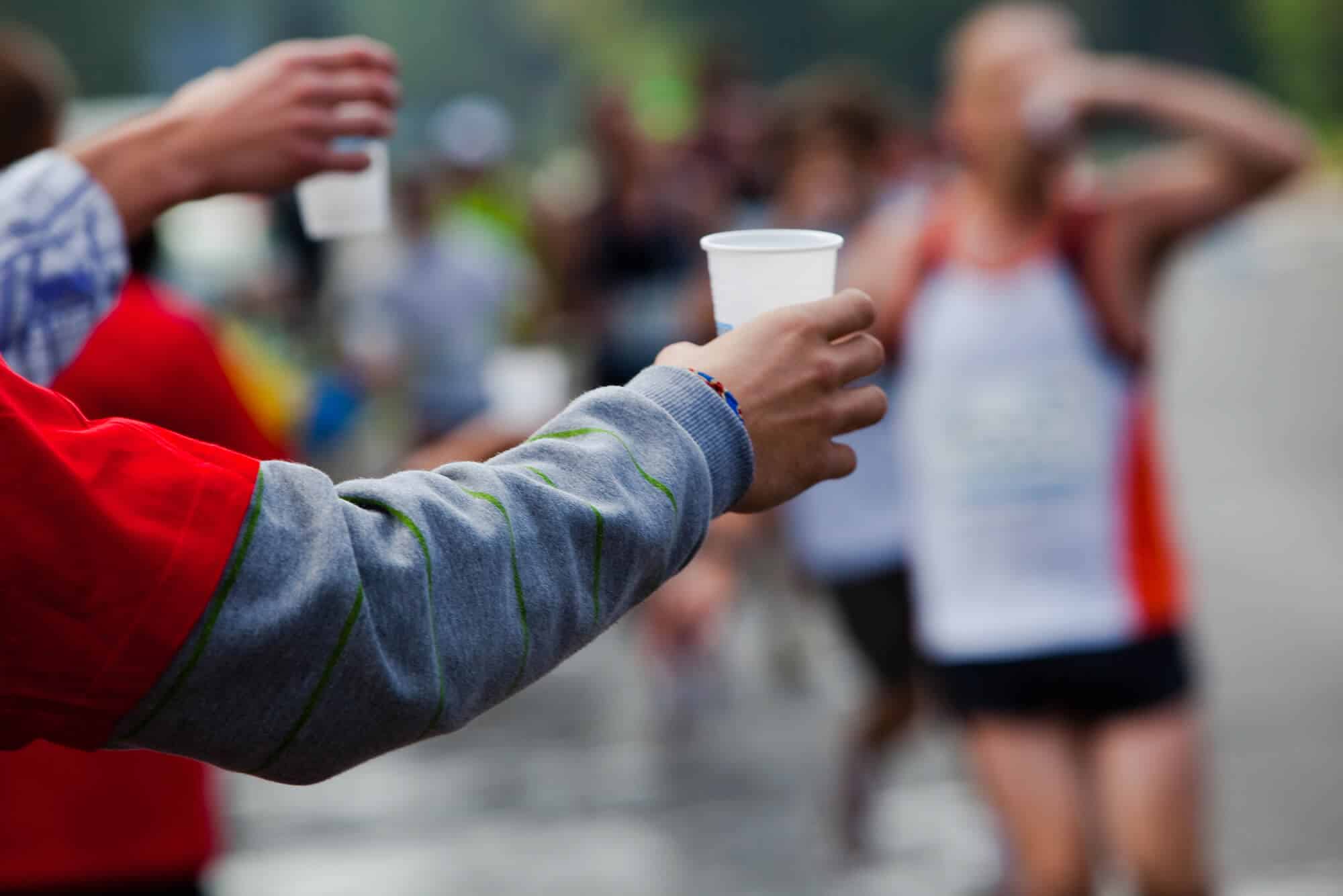 running a half marathon for the first time:Runner take a water in a marathon race