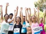 Group of marathon runners cheering after winning a race in the park