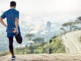 Full length shot of an unrecognisable man standing alone and stretching during his outdoor workout.