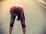 tired woman runner taking a rest after running hard on city road